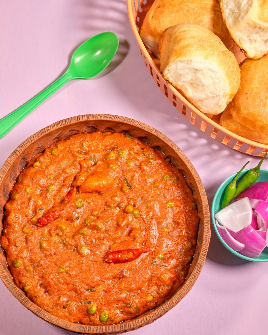 Würziges Pav Bhaji mit fluffigen Brötchen, grünen Chilis und roten Zwiebeln – beliebtes Streetfood aus Mumbai, vorgestellt im Kochbuch Karma Food Currys – eine kulinarische Reise durch Indien